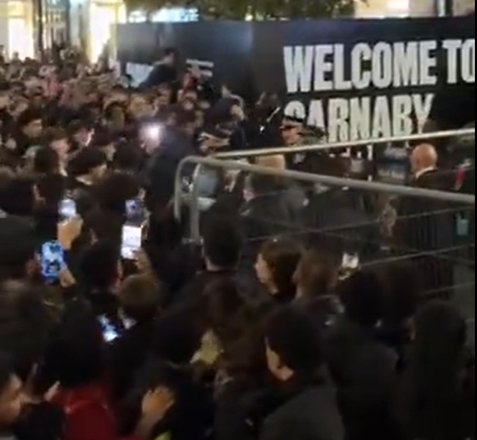 Eine große Menschenmenge hinter Absperrungen vor dem London Palladium.