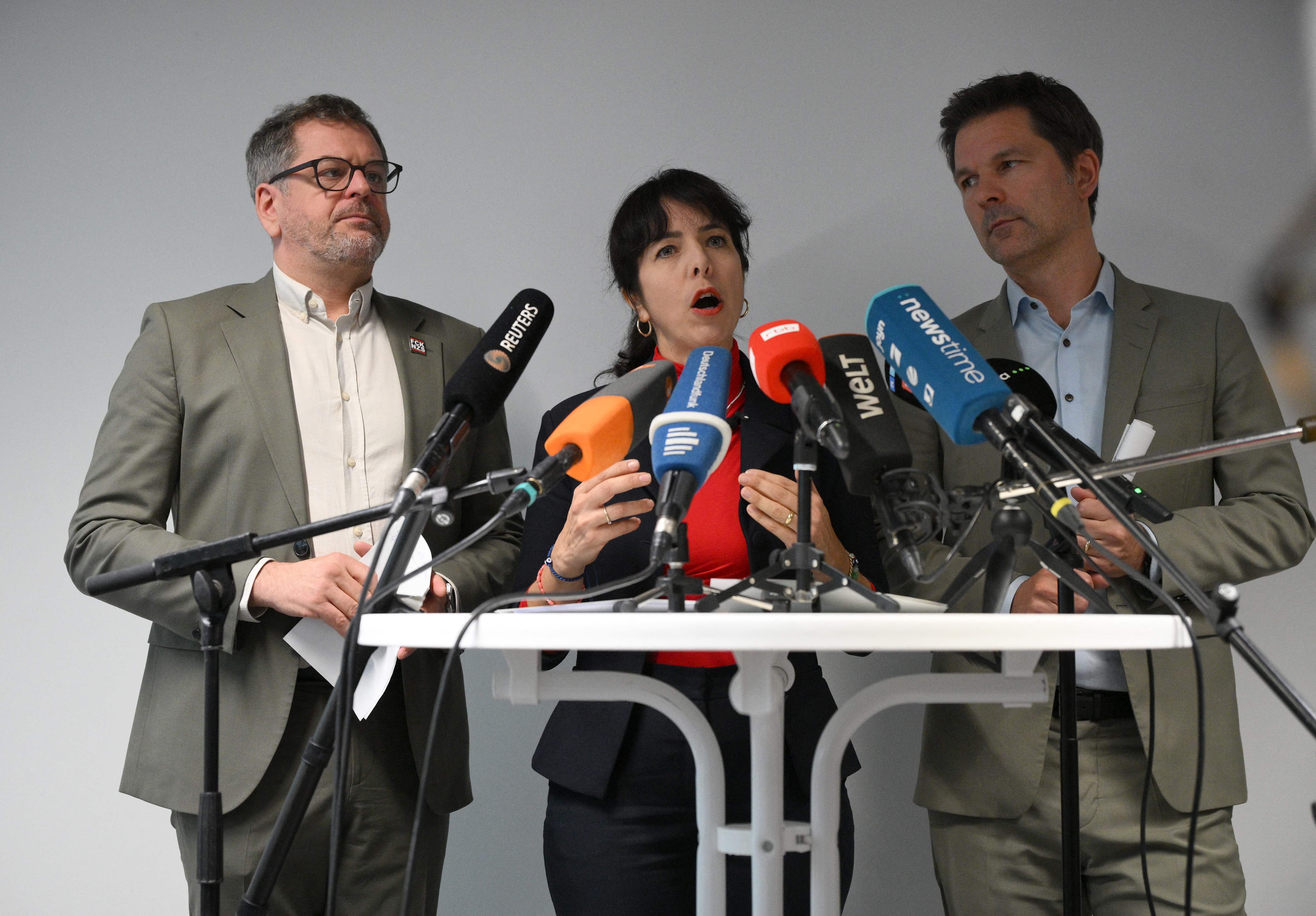 Drei Politiker sprechen bei einer Pressekonferenz, vor ihnen stehen mehrere Mikrofone.