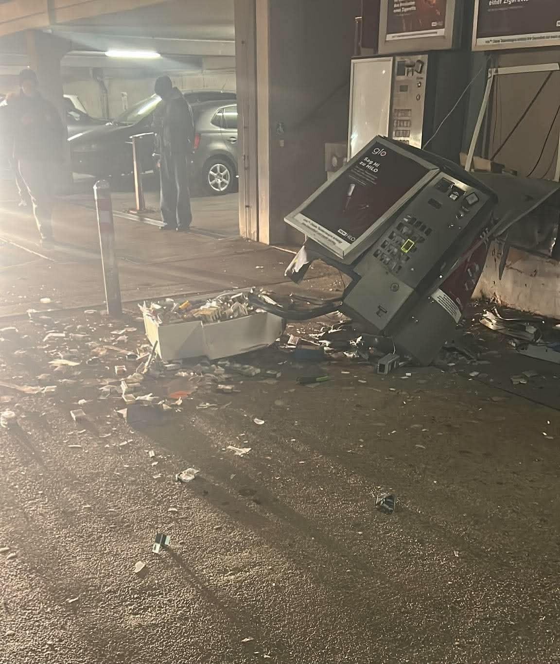 Ein zerstörter Zigarettenautomat liegt in einem Parkhaus, Zigaretten liegen verstreut am Boden.