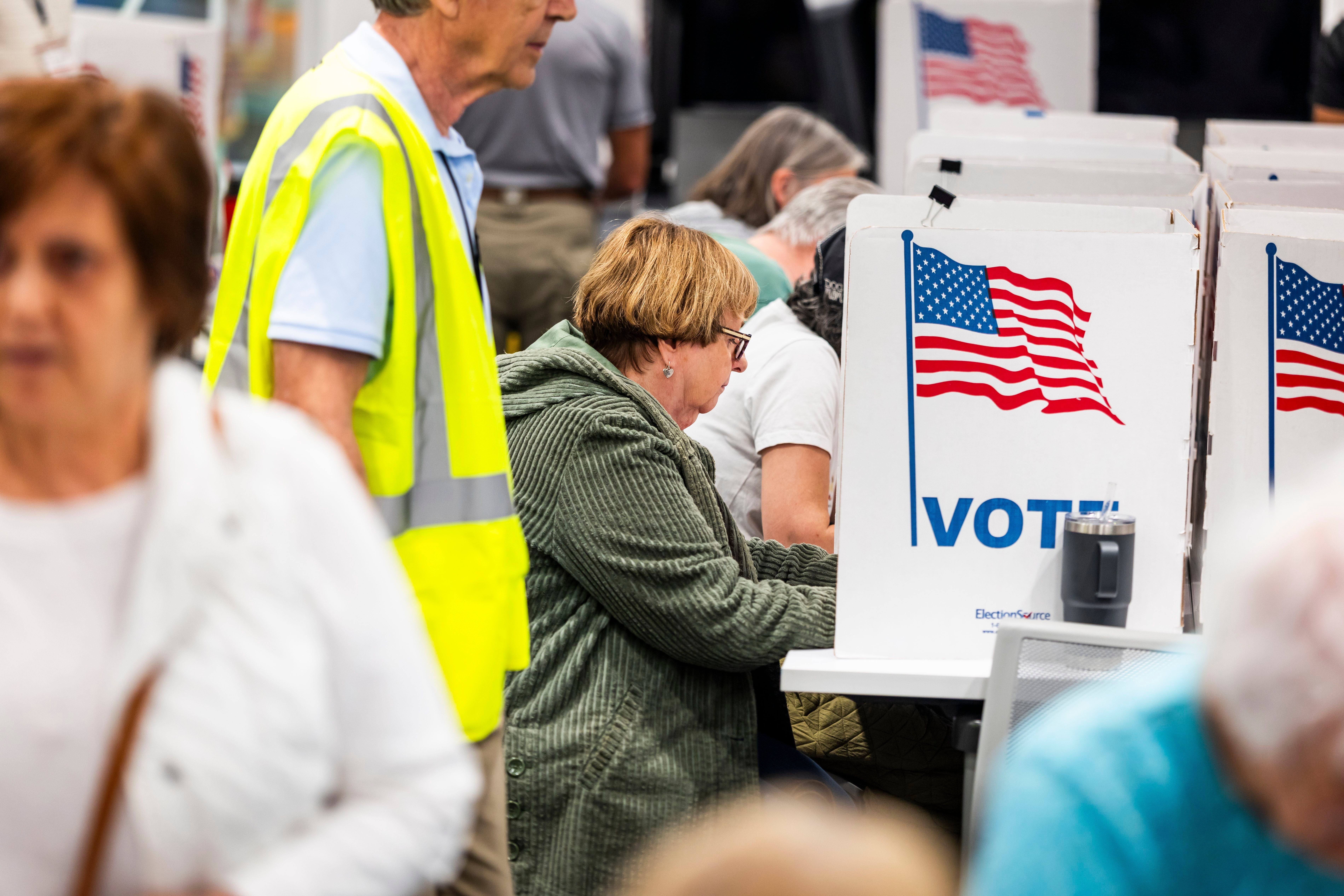 Menschen geben bei der Frühwahl in privaten Wahlkabinen in den USA ihre Stimmen ab.