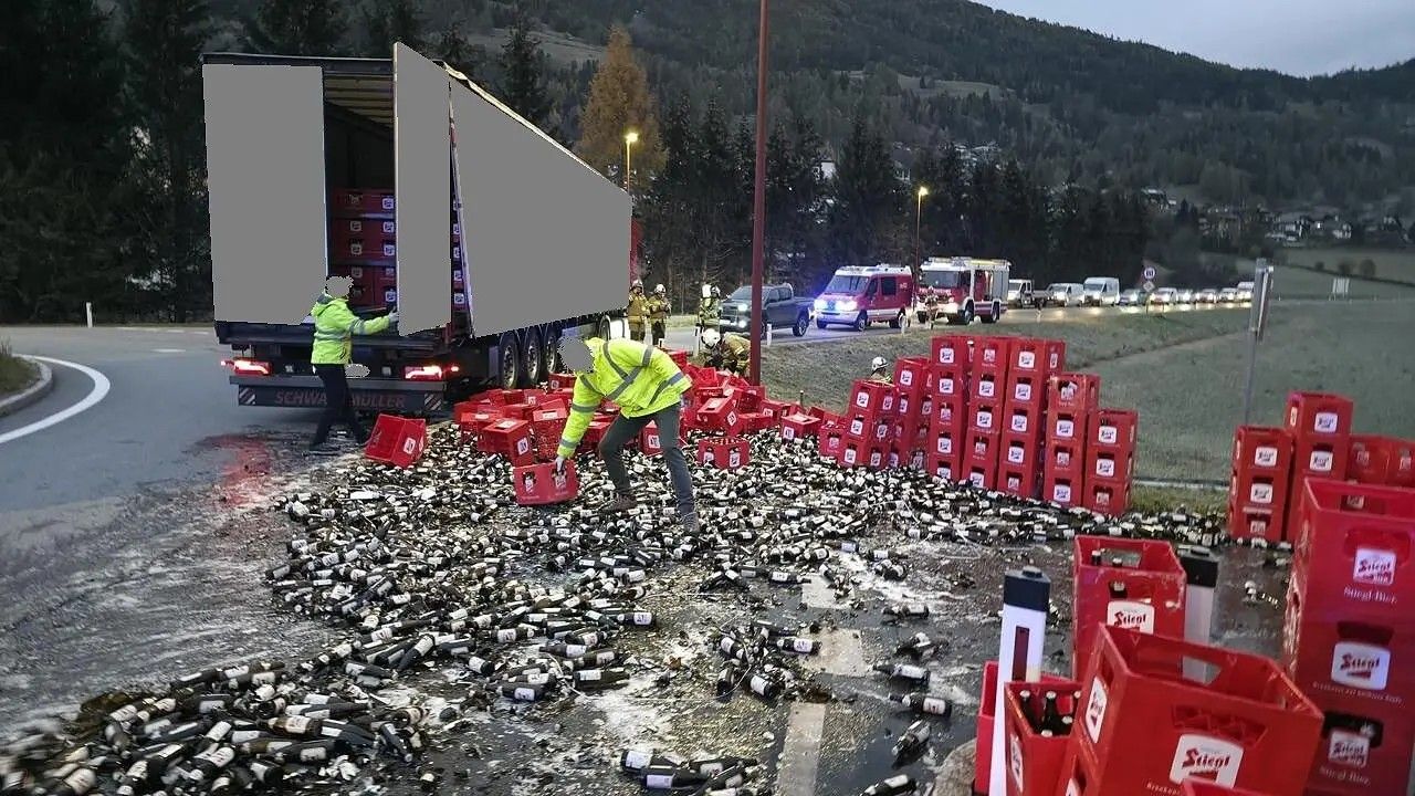Viele zerbrochene Bierflaschen und Kisten liegen nach einem Unfall verstreut auf der Straße.