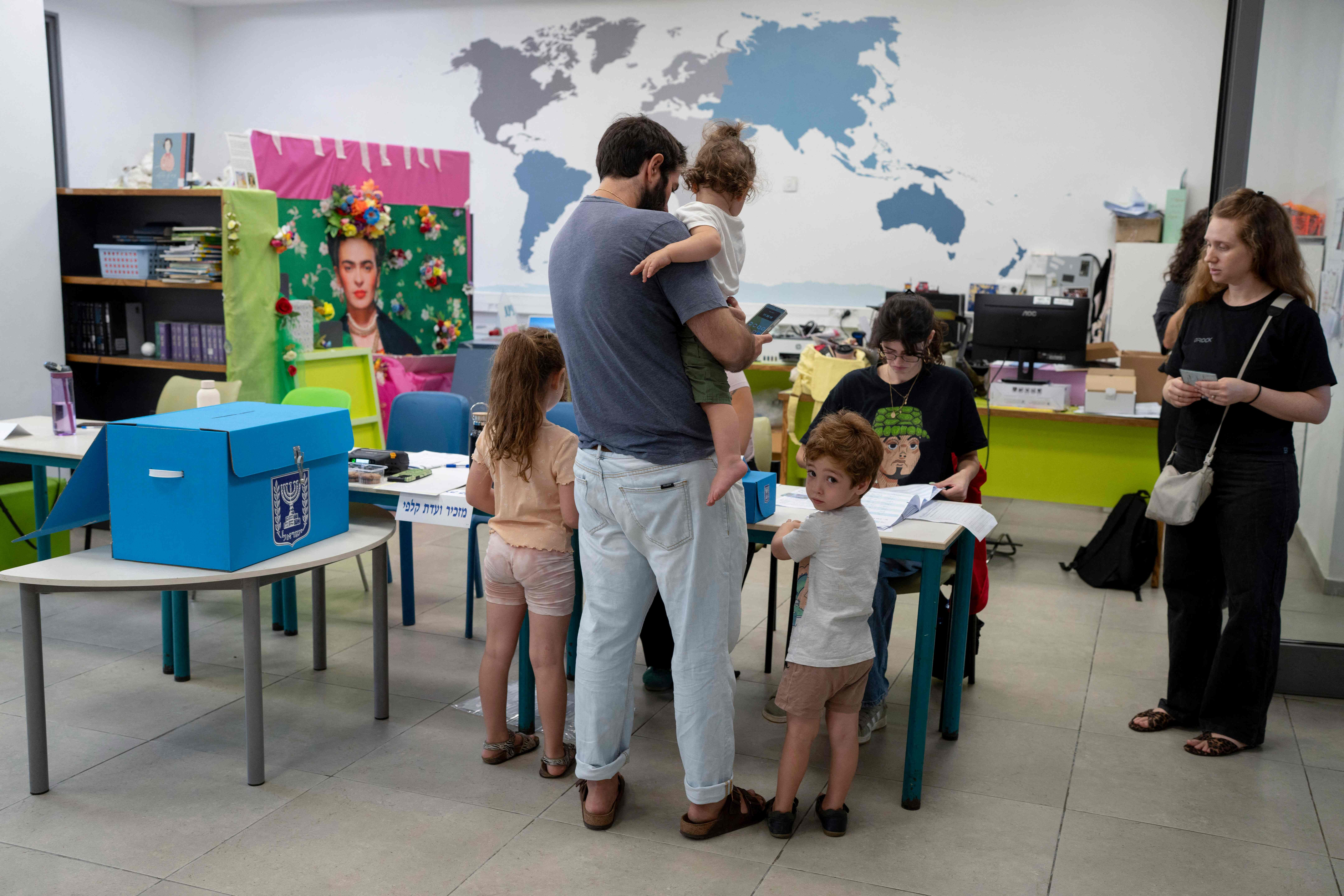 Ein Mann mit drei Kindern stimmt an einer Wahlstation in Bnei Brak während Israels Parlamentswahl ab.