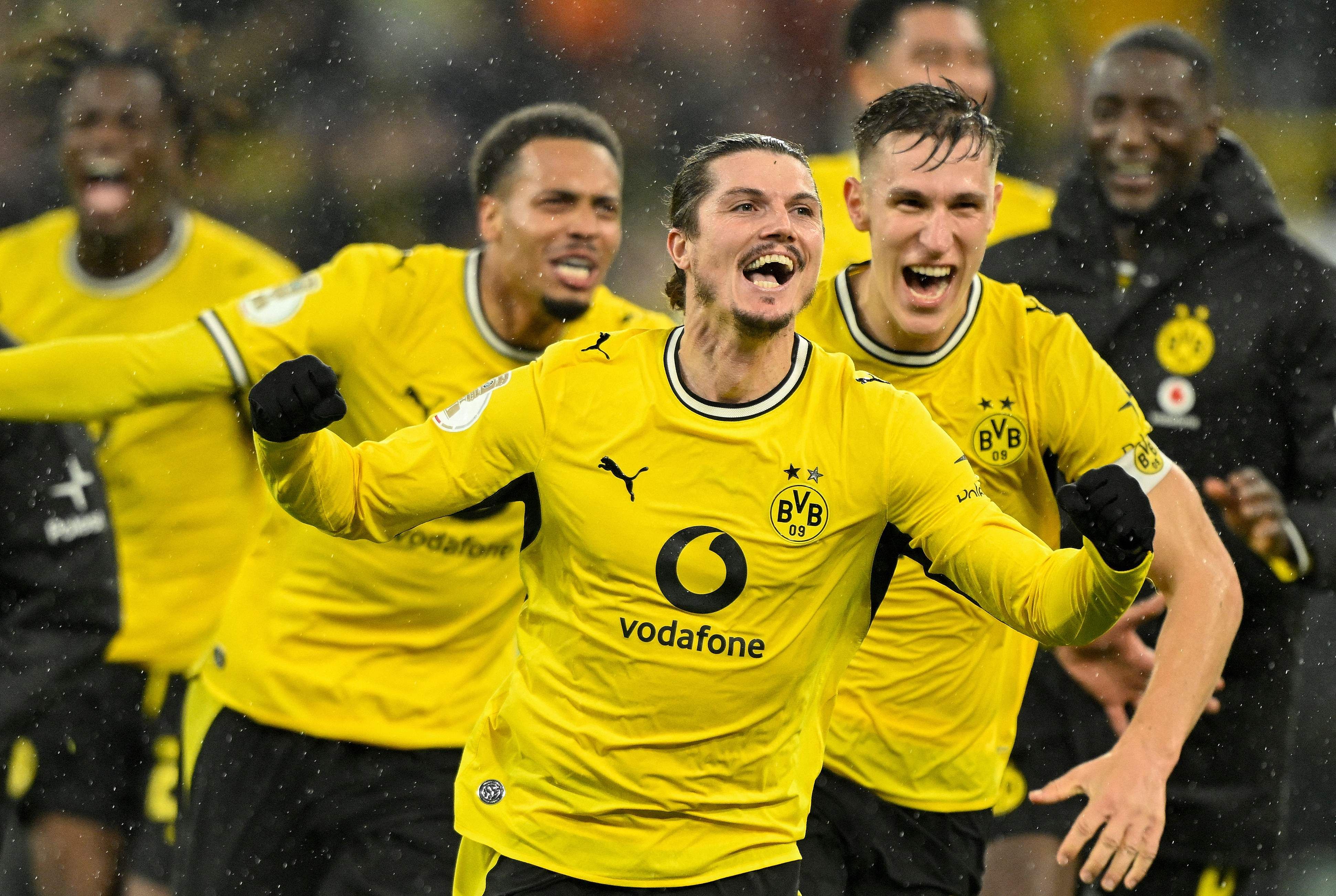 Mehrere Borussia-Dortmund-Spieler jubeln im gelben Trikot nach einem Tor im Fußballstadion.
