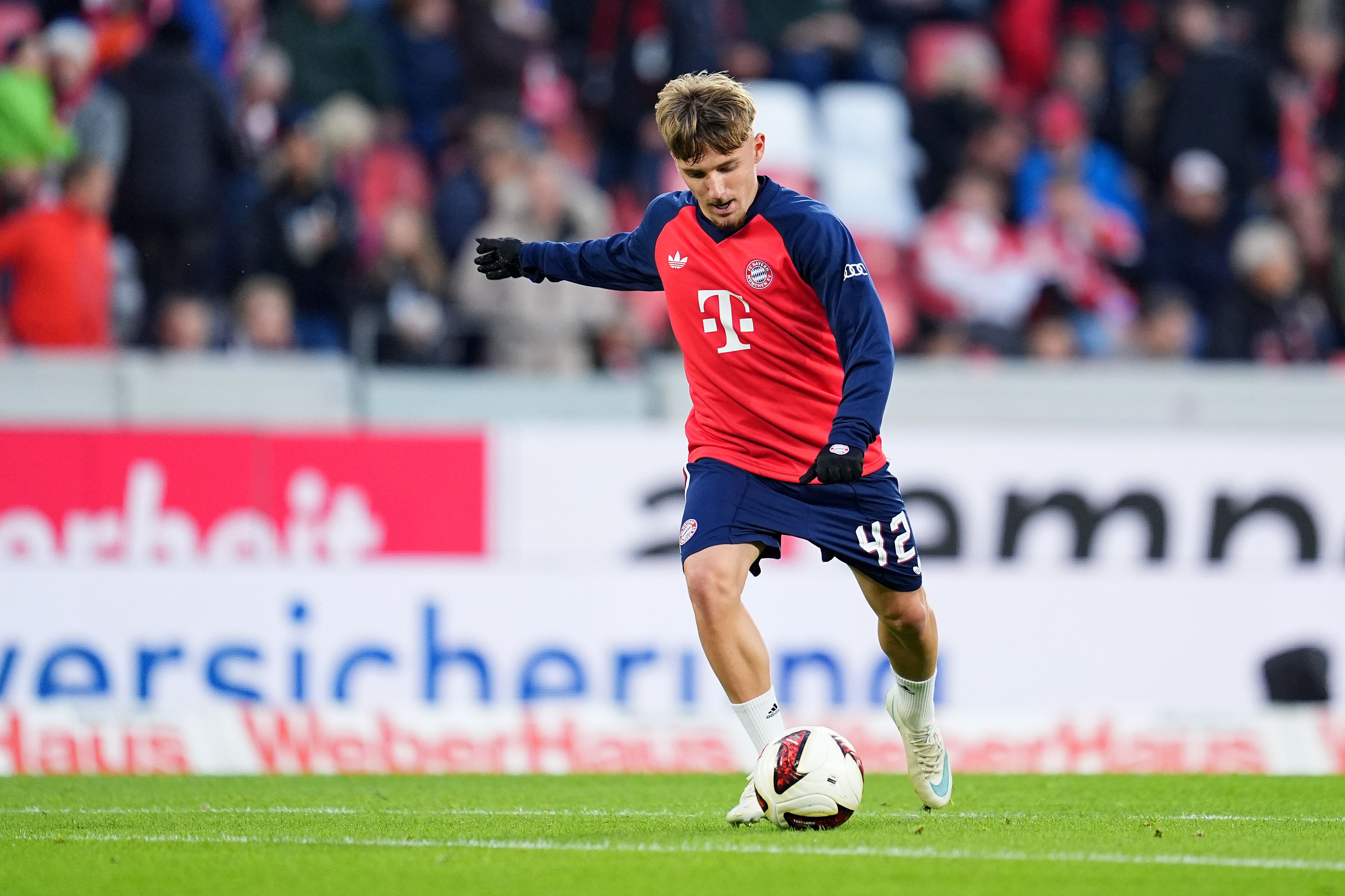 Ein Spieler des FC Bayern München wärmt sich vor einem Spiel auf dem Fußballfeld auf.