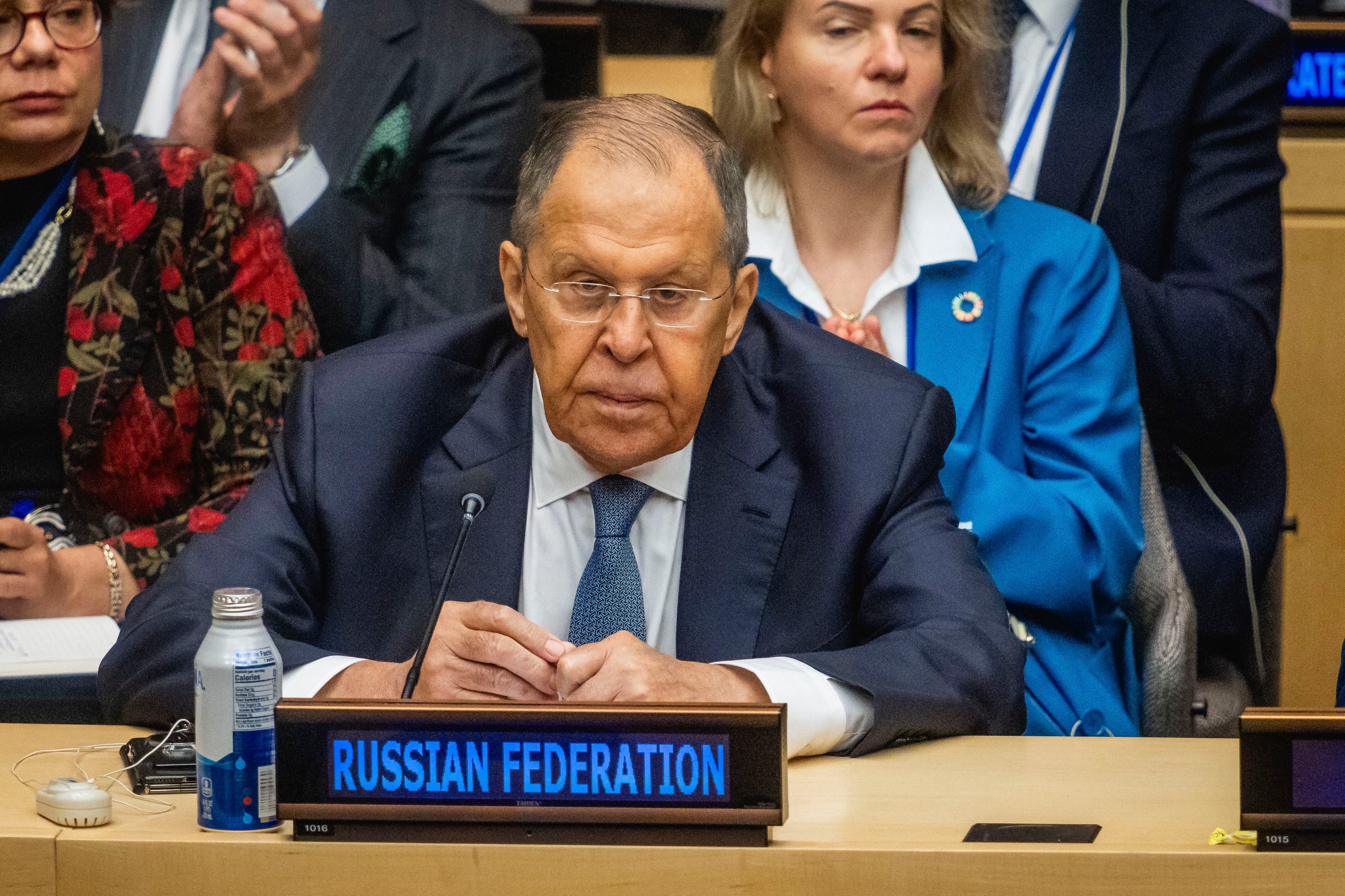 Sergey Lavrov sitzt bei einer G20-Außenministerkonferenz hinter einem Schild „Russian Federation“.