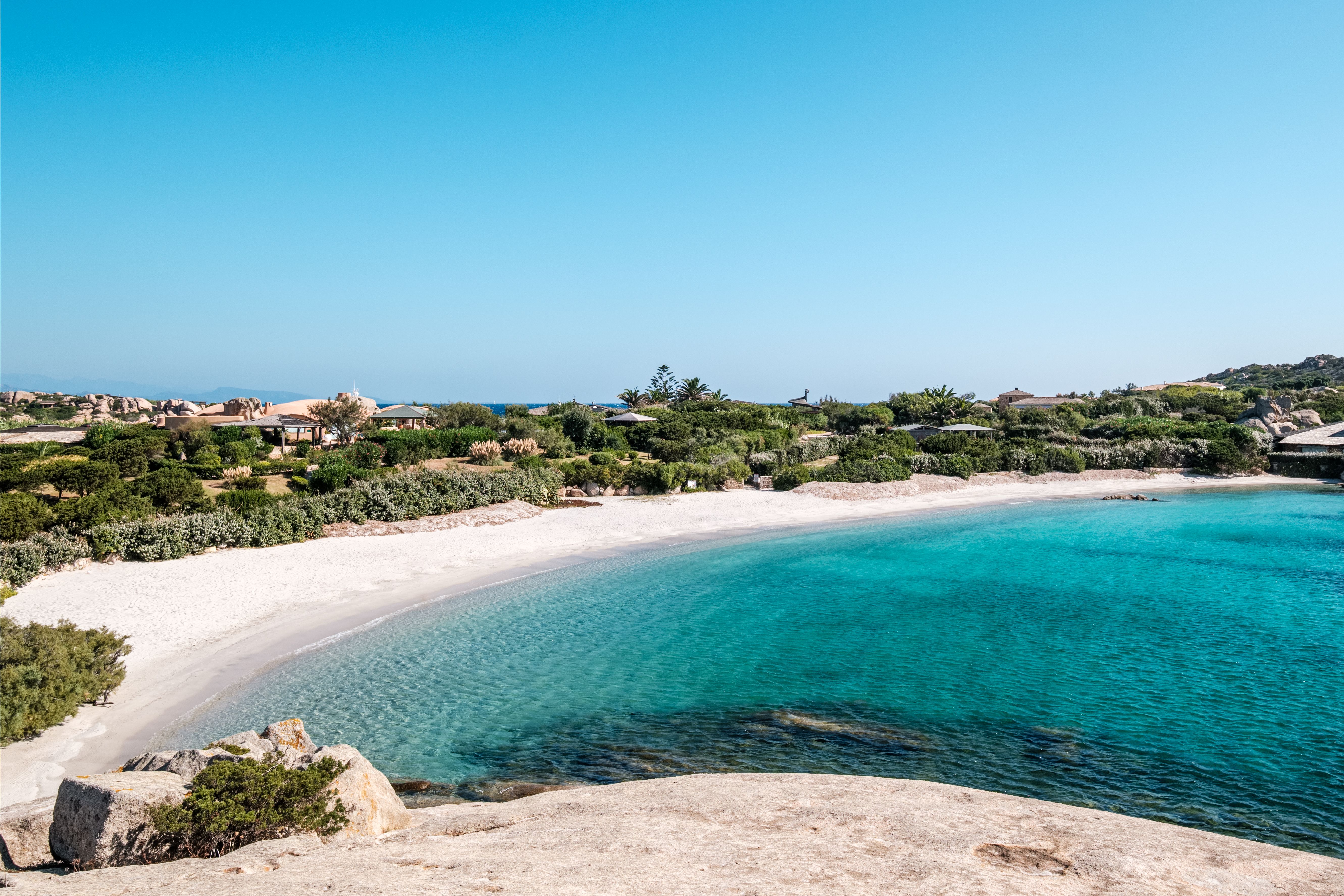 Weiße Sandbucht mit türkisblauem Meer und grüner Vegetation auf der Insel Cavallo, Korsika.