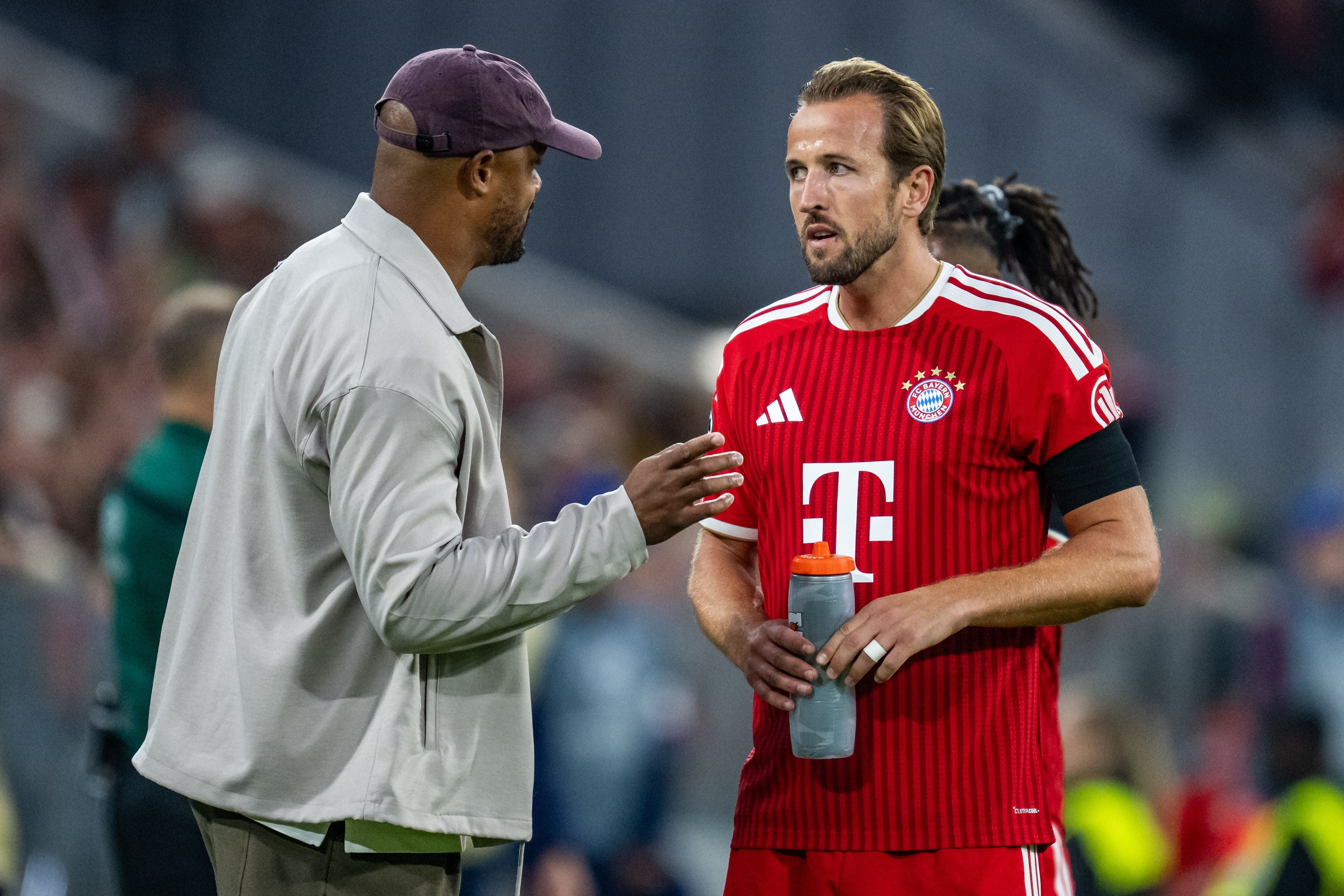 Trainer und Spieler des FC Bayern München unterhalten sich am Spielfeldrand während eines Spiels.