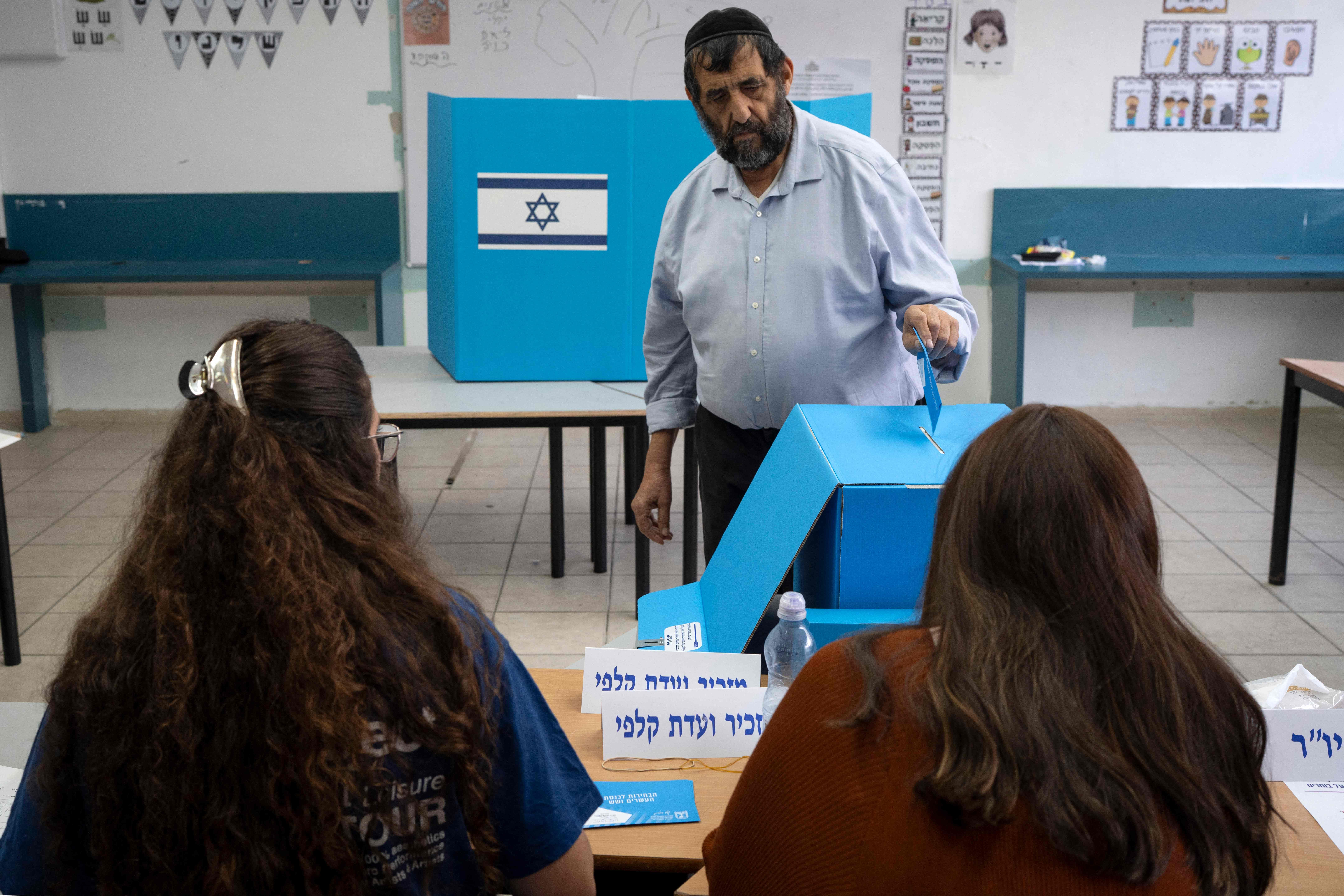 Ein Mann wirft seinen Stimmzettel in eine Wahlurne in einem israelischen Wahllokal.