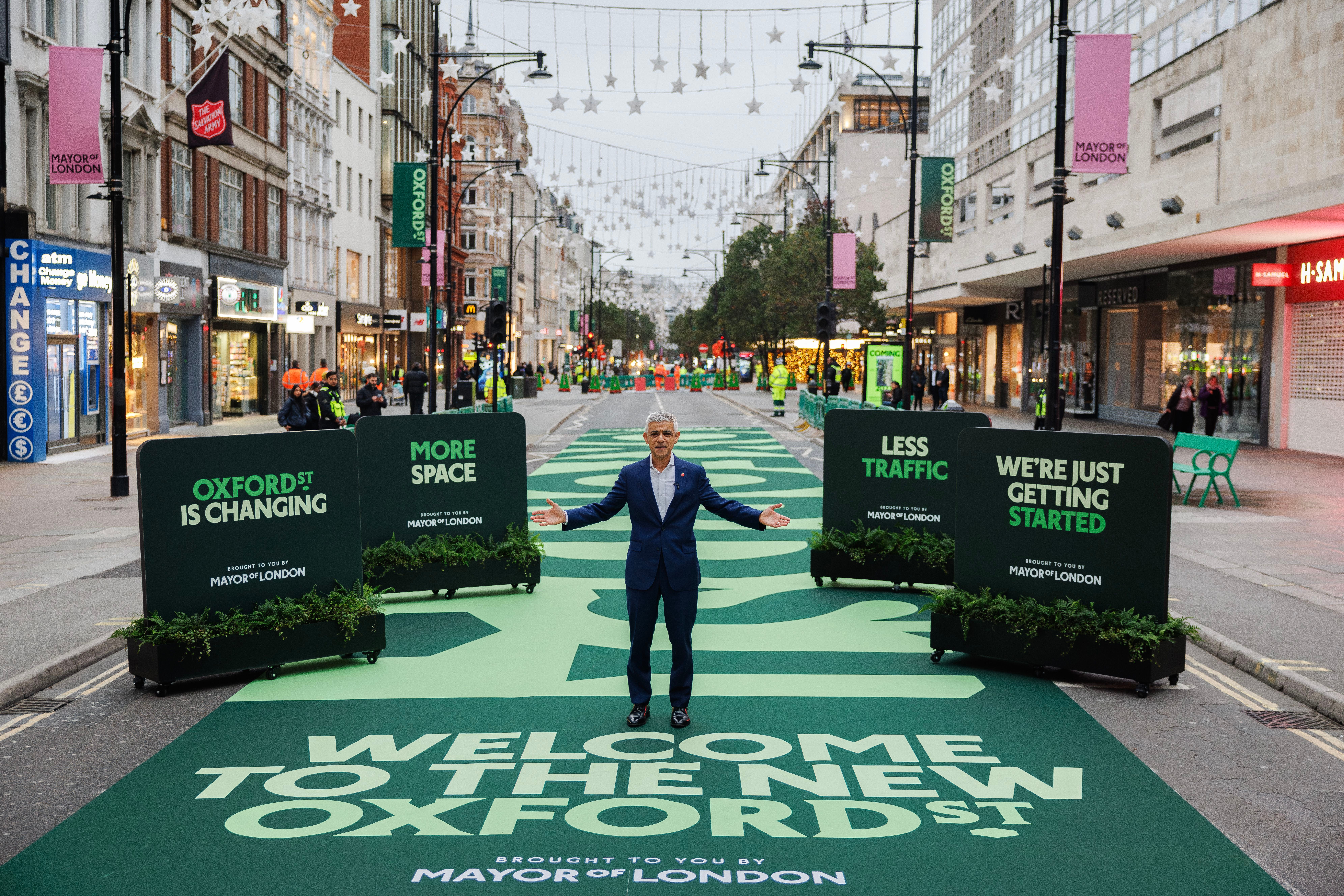 Ein Mann steht auf grünem Teppich inmitten der autofreien Oxford Street in London.