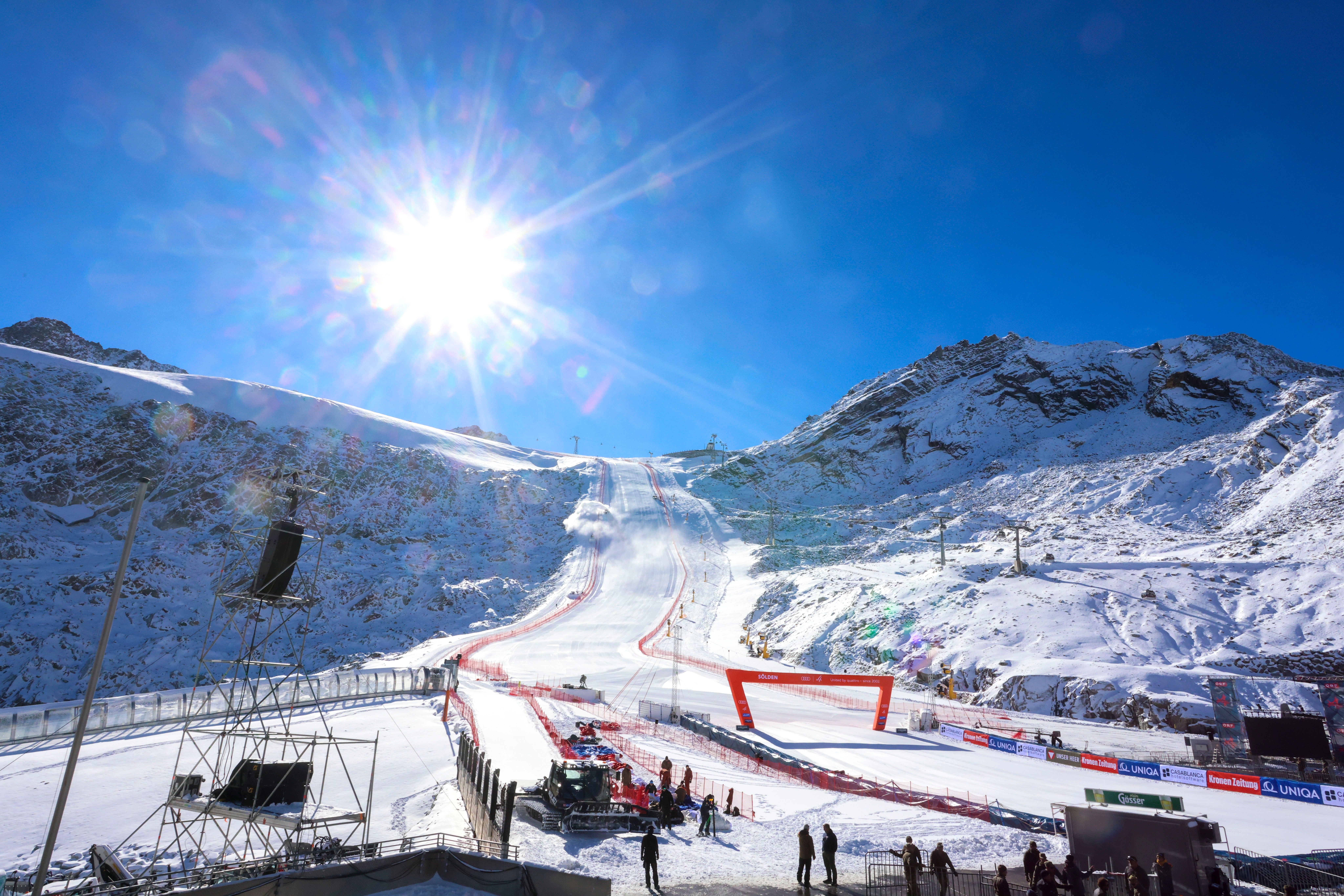Sonnige Ski-Piste mit Zielbereich beim Weltcup-Auftakt in Sölden, umgeben von verschneiten Bergen.
