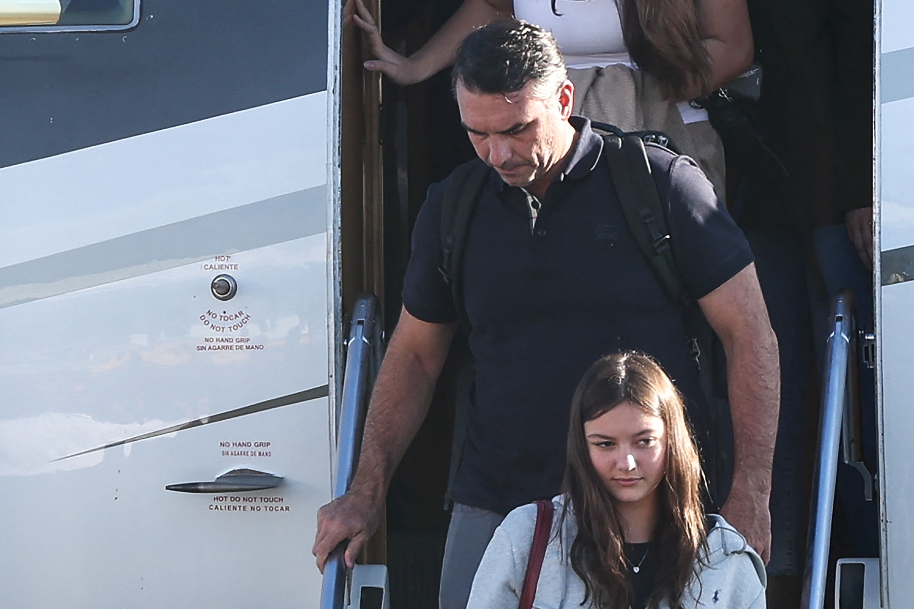 Ein Mann und ein Mädchen steigen die Treppe eines Flugzeugs hinunter.