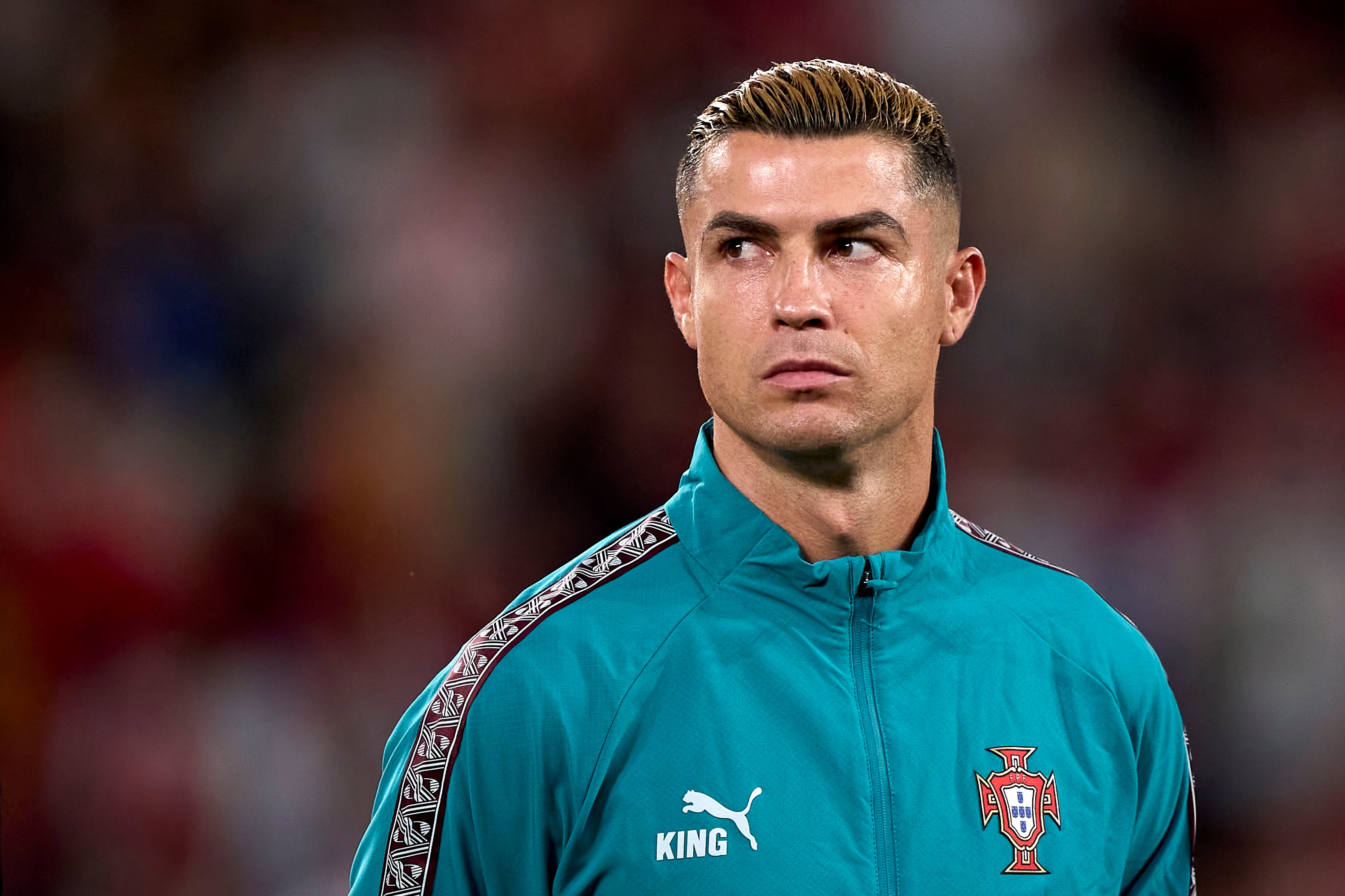 Ein Fußballspieler im türkisfarbenen Portugal-Trainingsanzug blickt ernst zur Seite.
