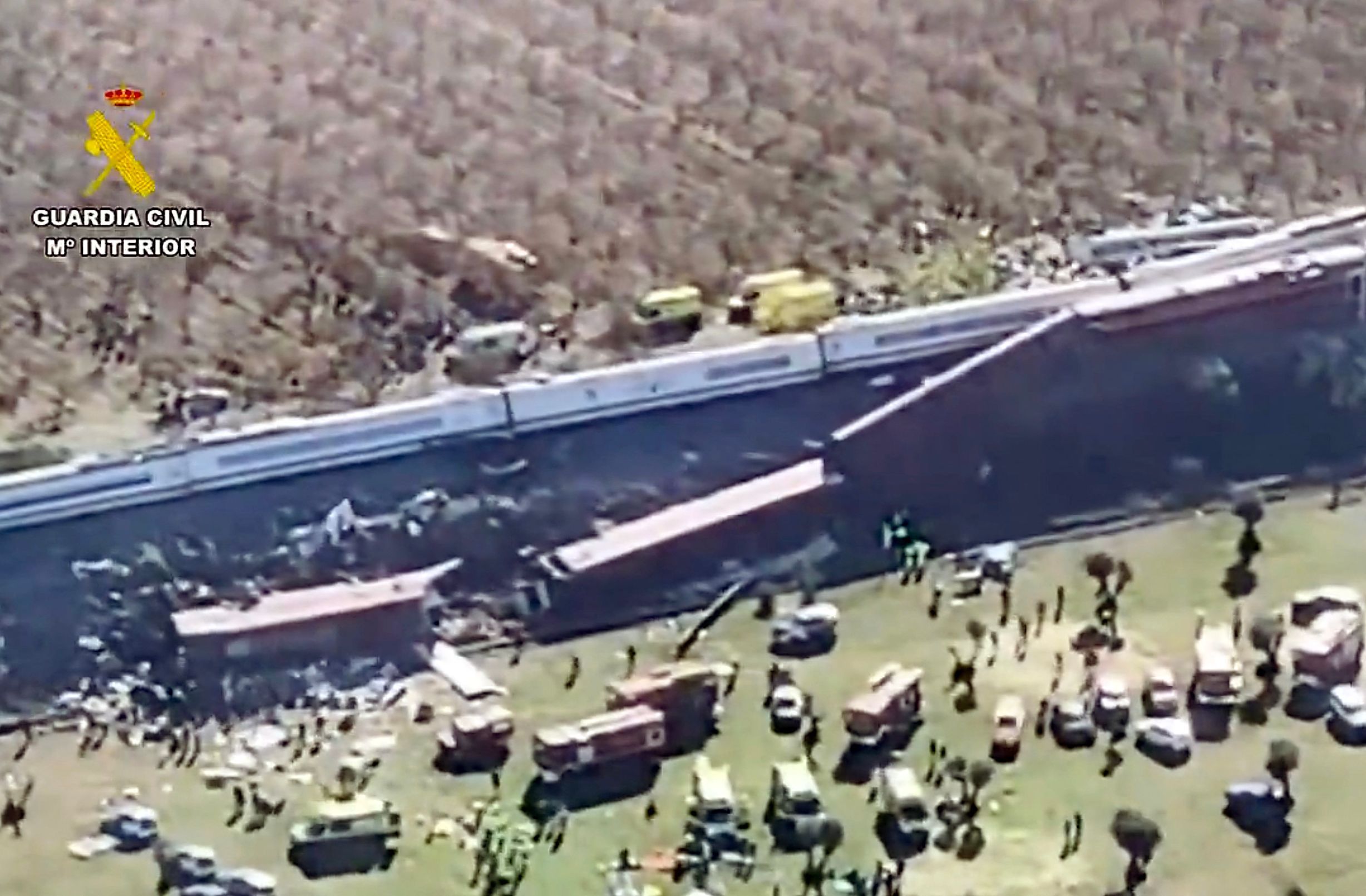 Luftaufnahme eines Zugunglücks mit entgleisten Waggons, Einsatzfahrzeugen und Rettungskräften.