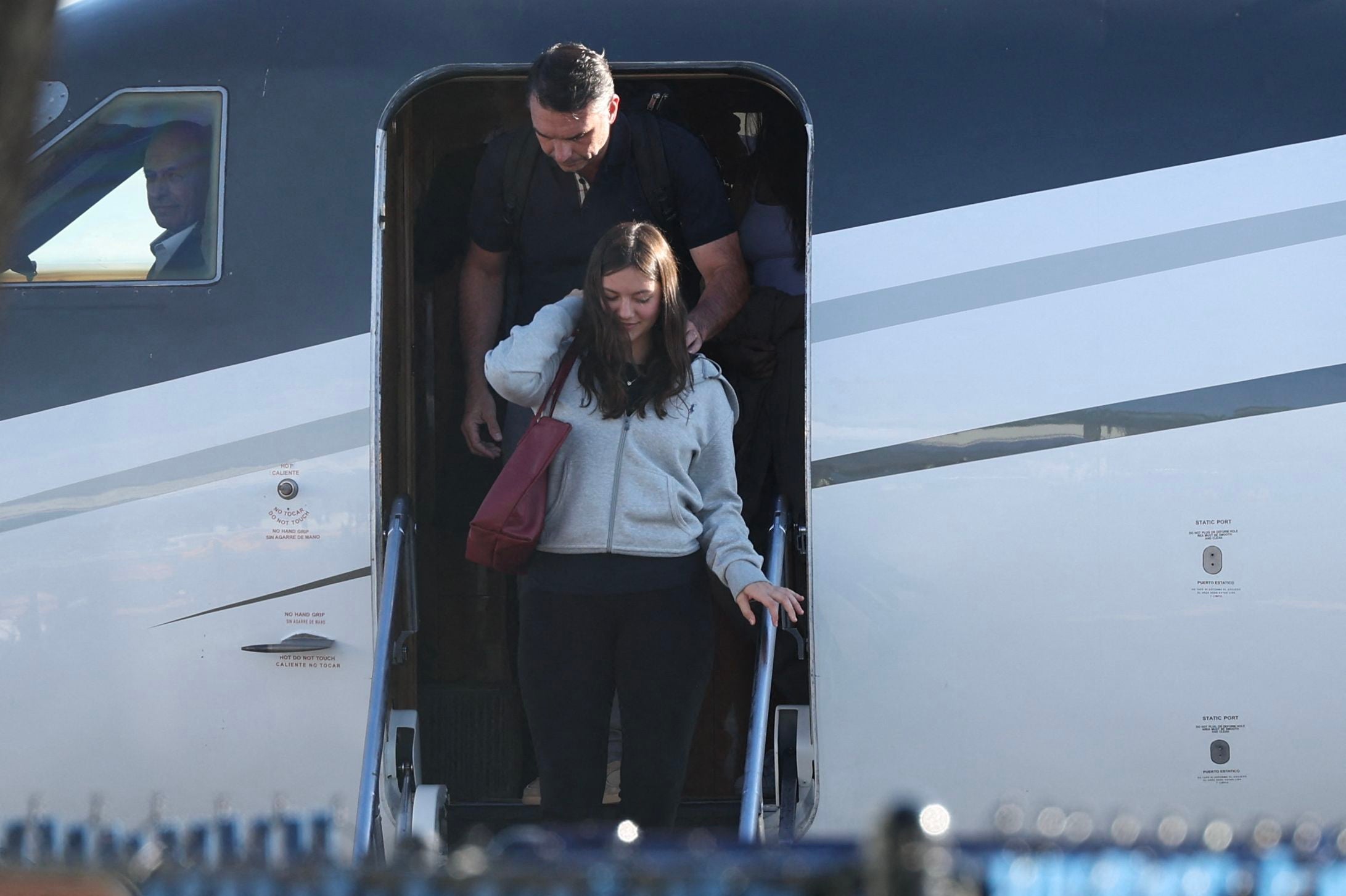 Menschen steigen die Treppe eines Privatflugzeugs am Flughafen hinunter.