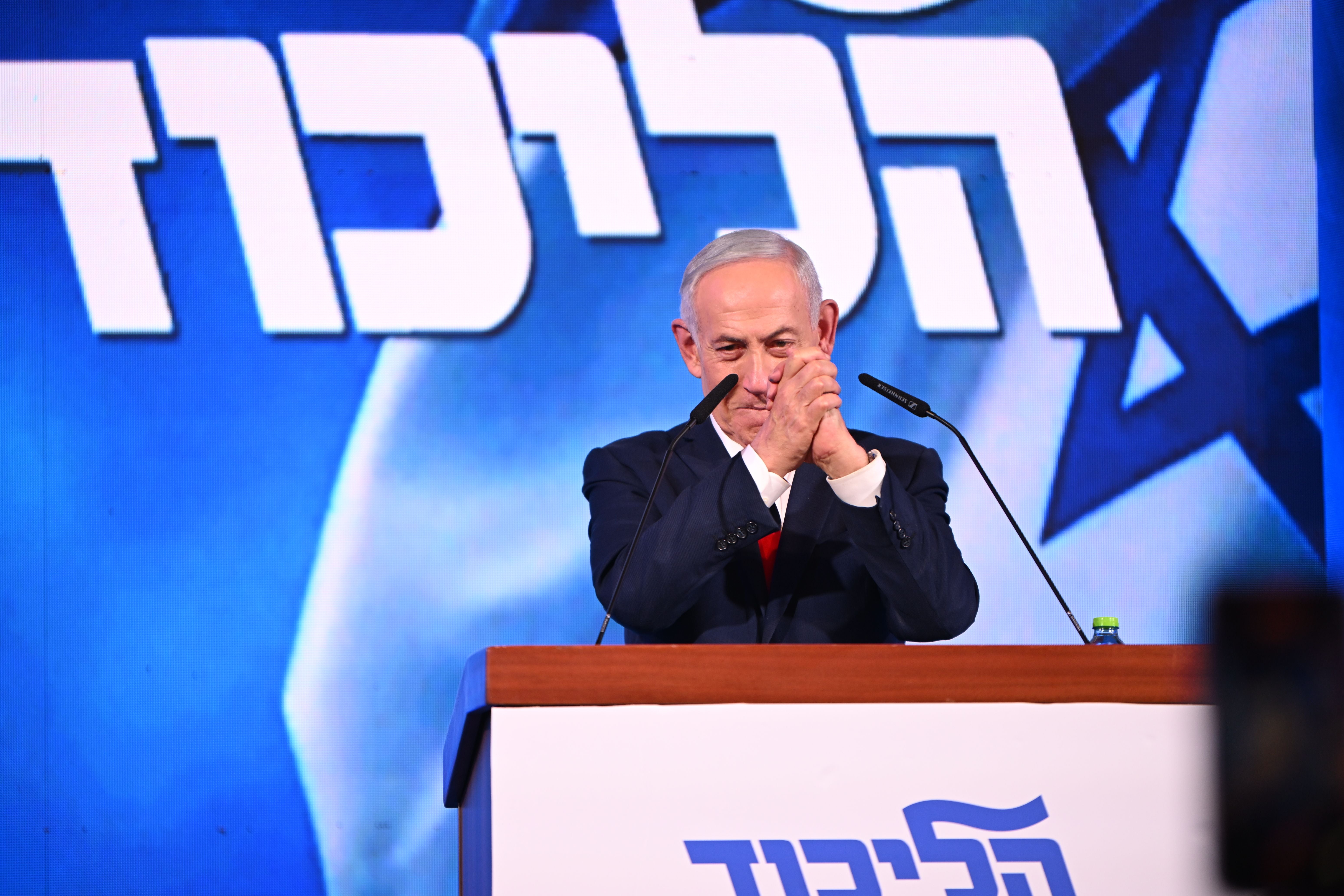 Ein Mann spricht an einem Rednerpult vor dem Likud-Logo und einer israelischen Flagge.