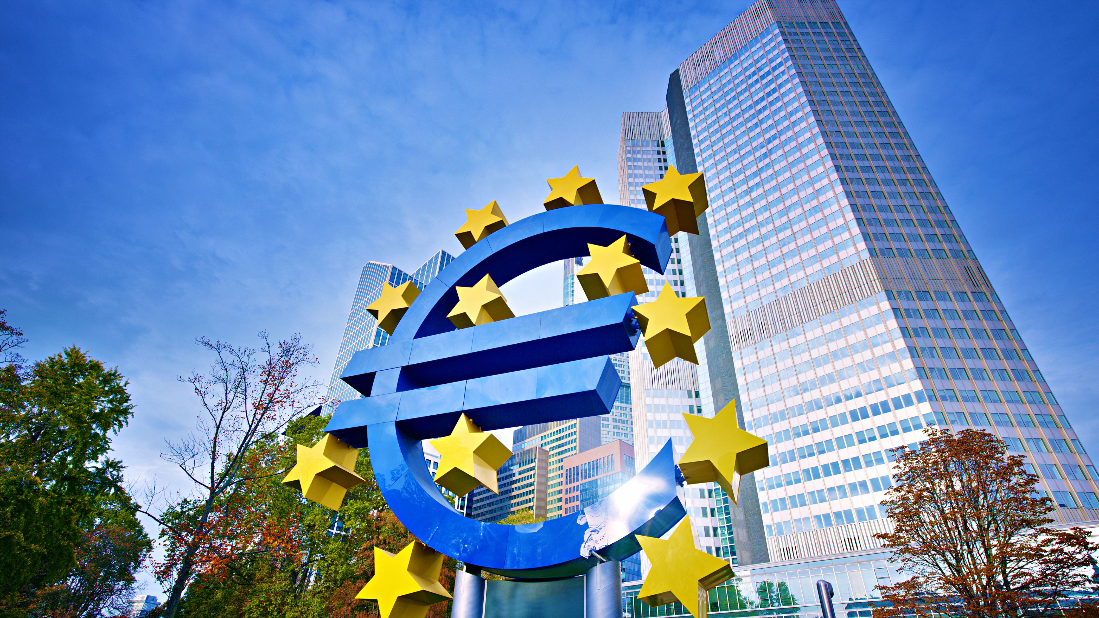 Großes Euro-Symbol mit gelben Sternen vor modernen Hochhäusern in Frankfurt am Main.