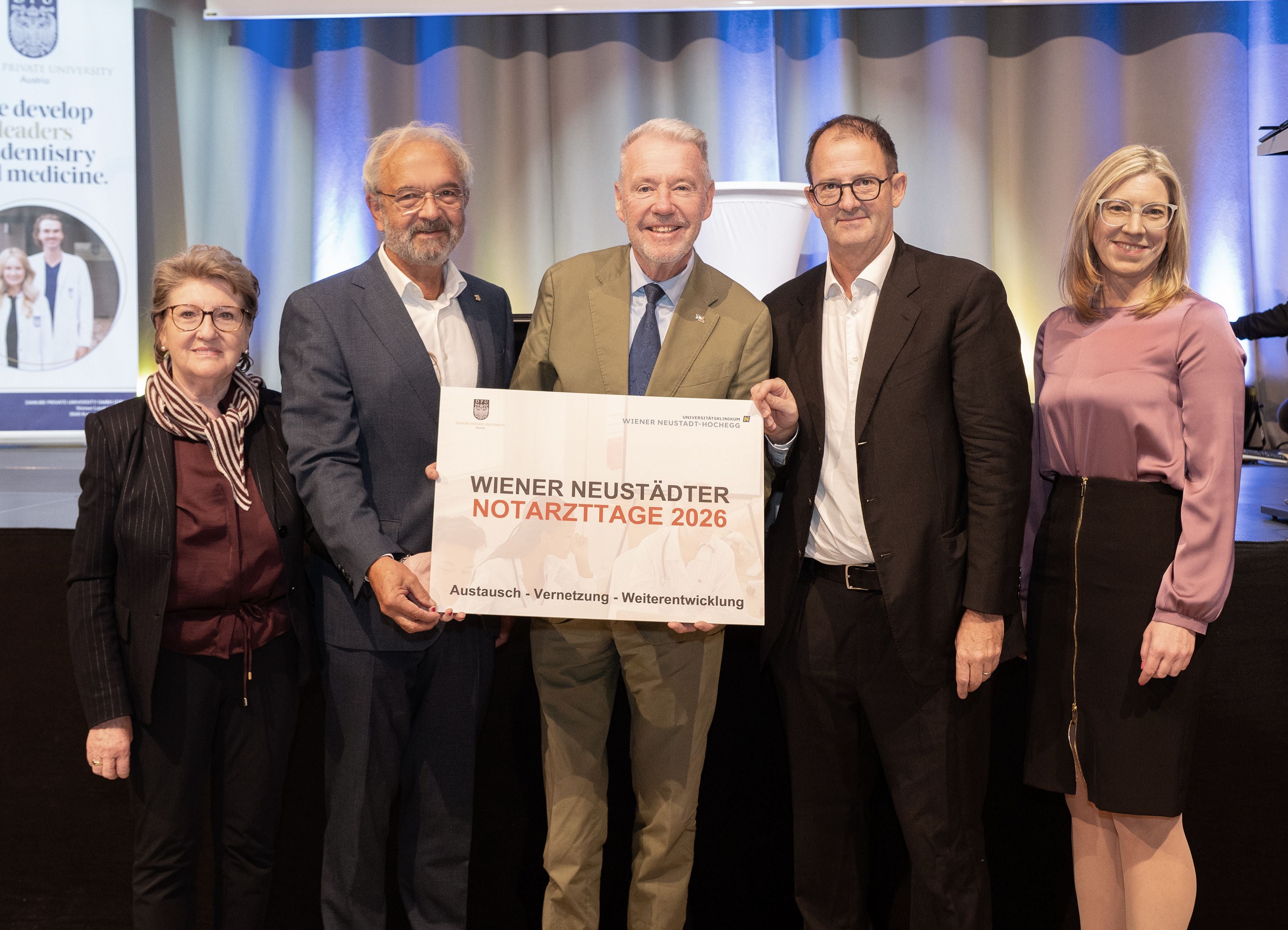 Fünf Personen halten ein Schild mit der Aufschrift „Wiener Neustädter Notarzttage 2026“.
