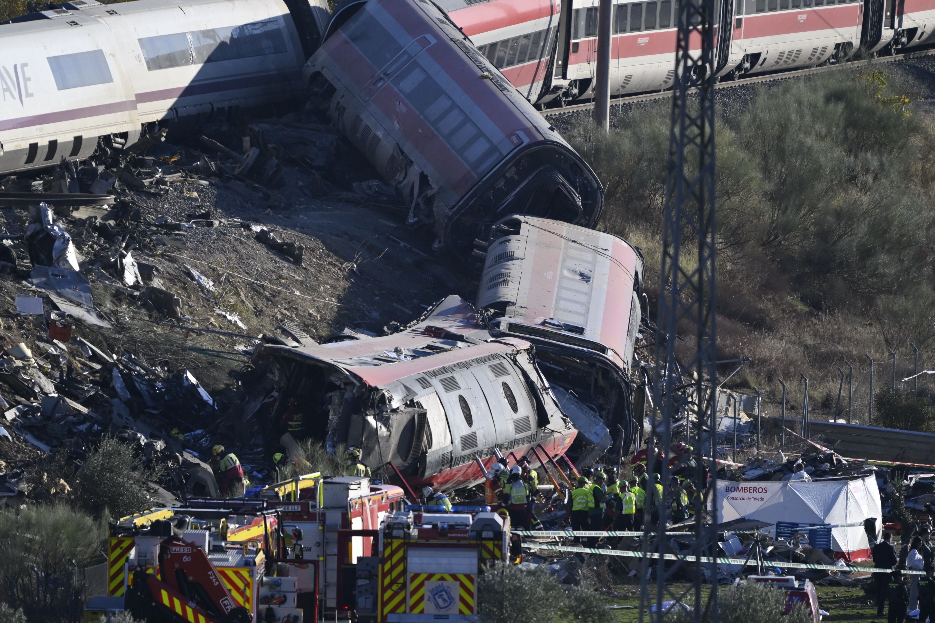 Entgleiste Hochgeschwindigkeitszüge mit Notfallkräften und Rettungsfahrzeugen am Unfallort.