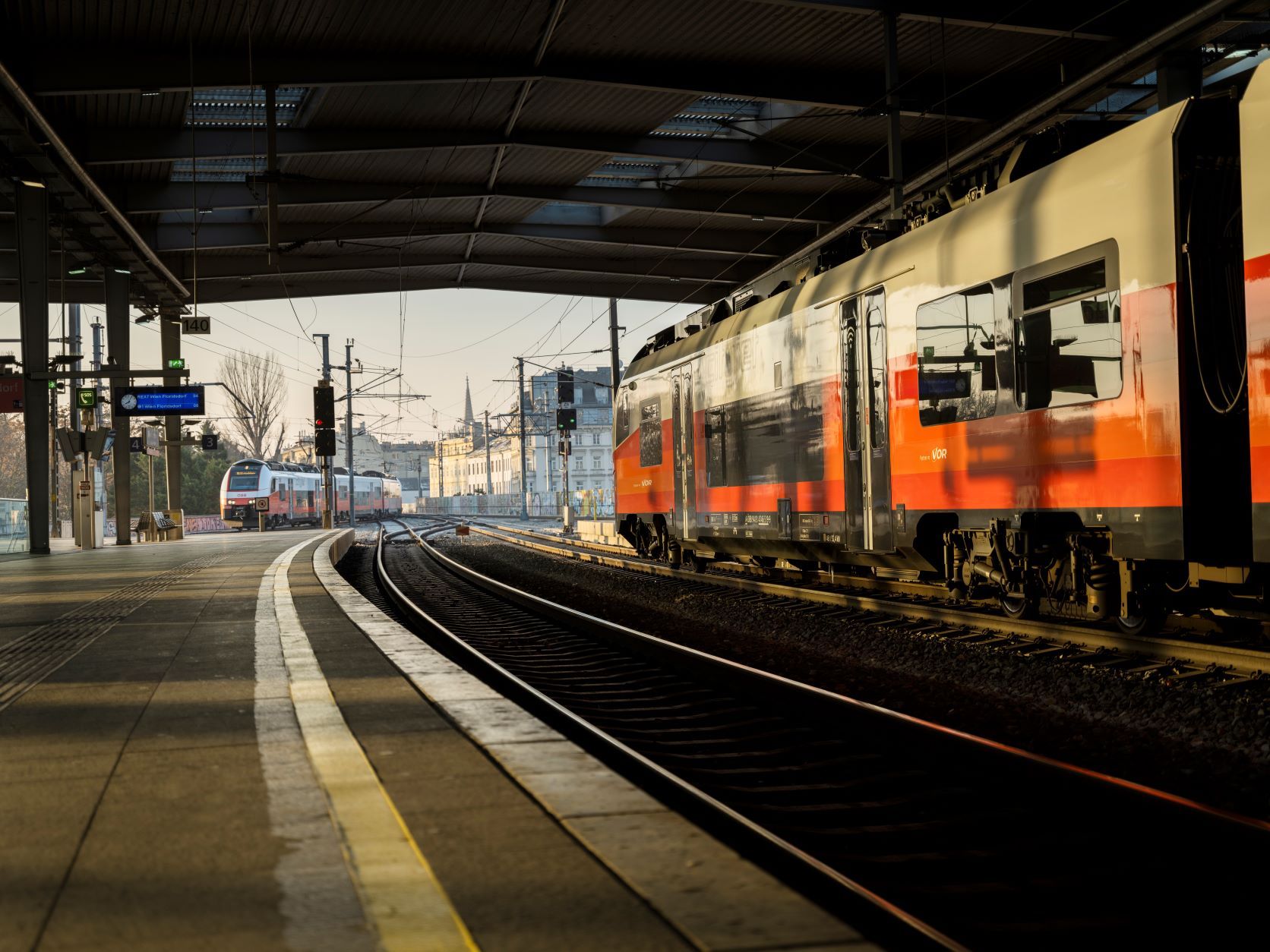 Zug steht am Bahnsteig des Bahnhofs Praterstern unter einem überdachten Dach.