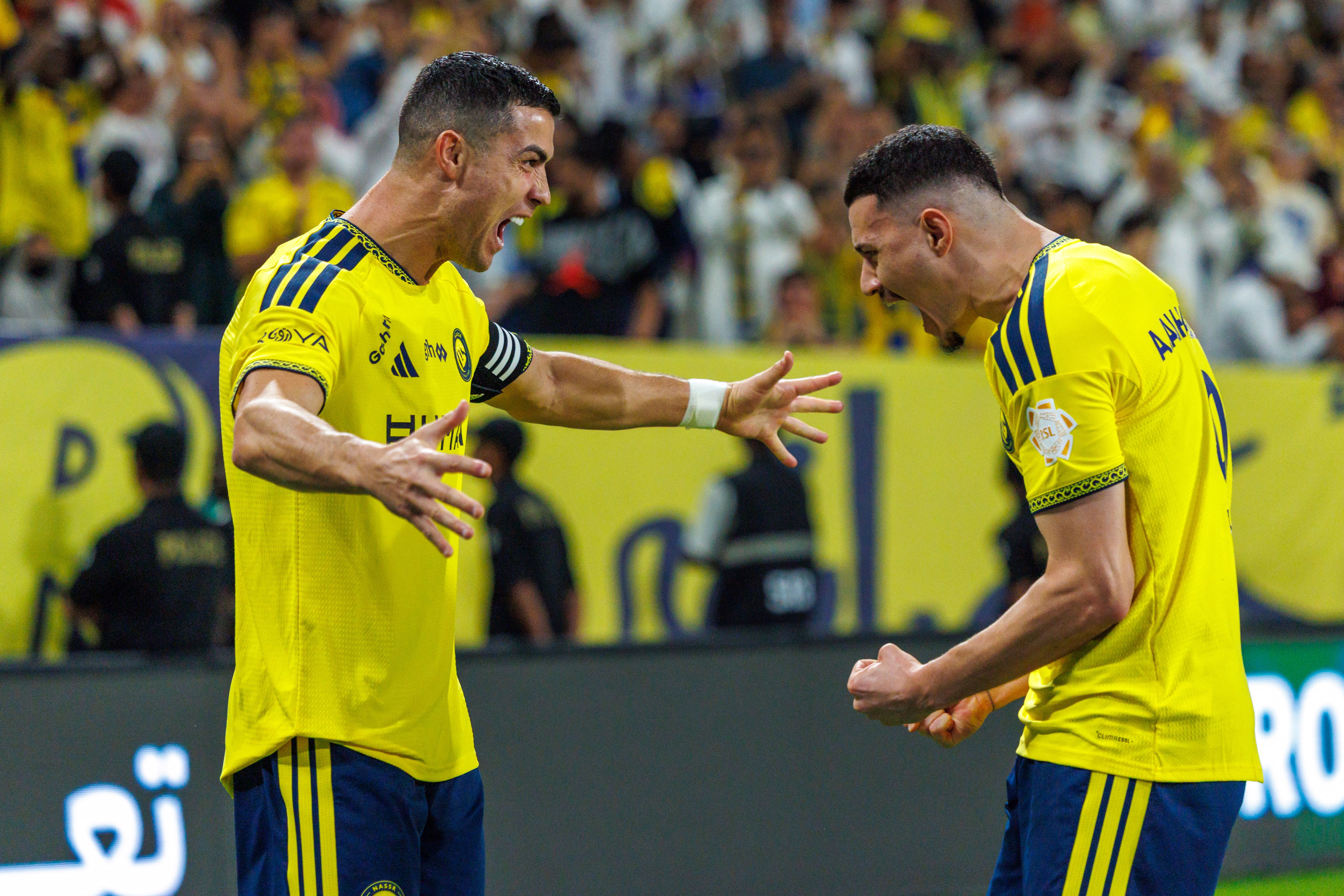 Cristiano Ronaldo jubelt im gelben Al-Nassr-Trikot lautstark gemeinsam mit seinem Teamkollegen Ângelo auf dem Spielfeld.
