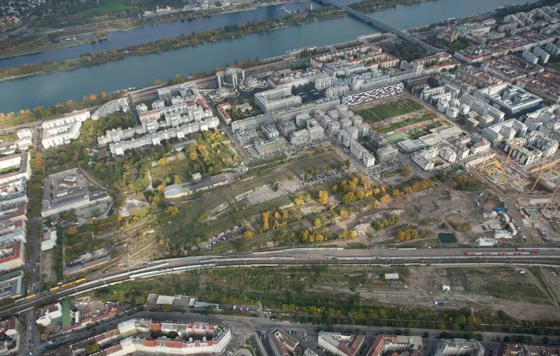 Luftaufnahme des Nordbahnviertels in Wien mit Wohngebäuden, Baustellen und Grünflächen.