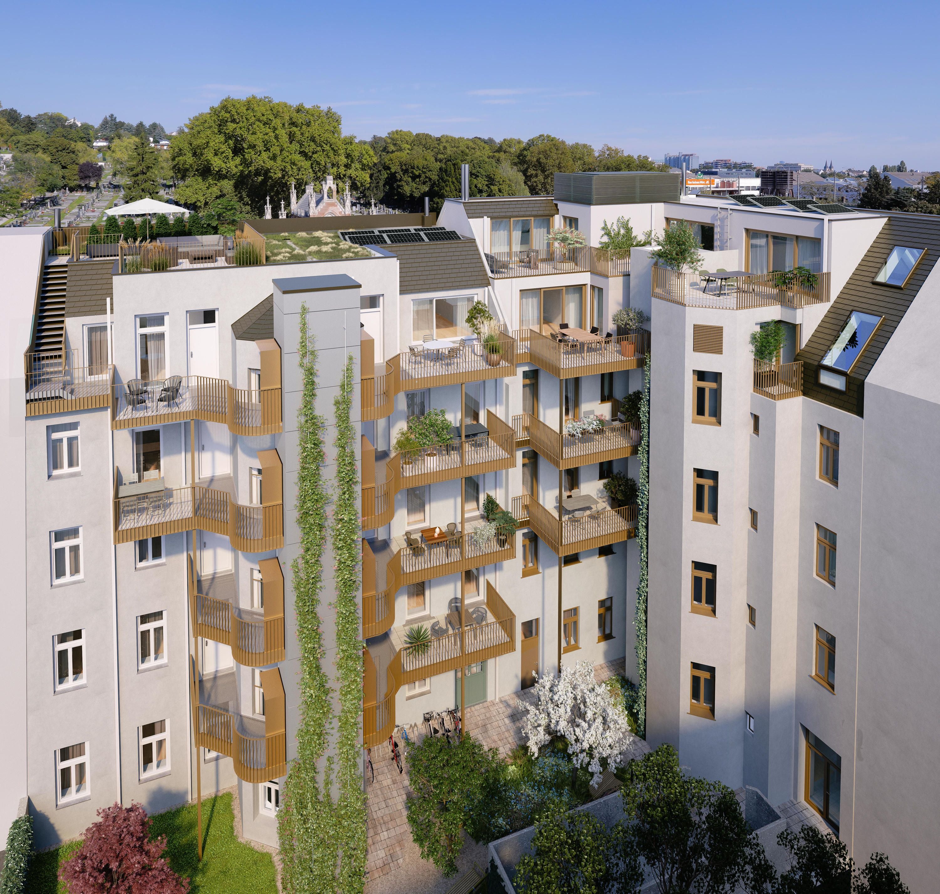 Modernes Wohnhaus mit mehreren Balkonen, begrüntem Innenhof und Dachterrassen bei sonnigem Wetter.