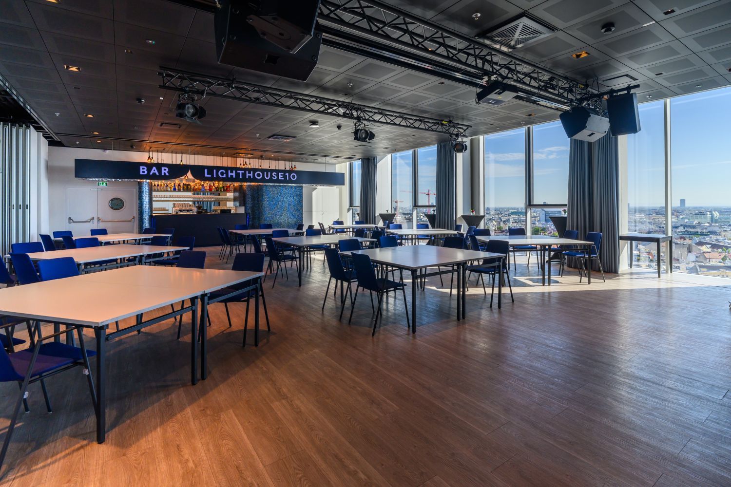 Moderner Bar- und Veranstaltungsraum mit großen Fenstern und Blick über die Stadt.