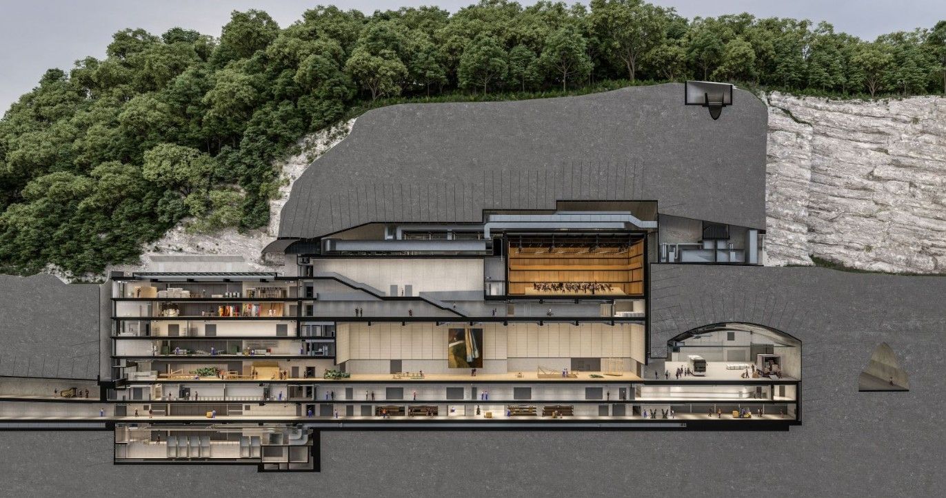 Querschnitt durch ein in den Felsen gebautes Festspielhaus mit mehreren Ebenen und Bühnen.