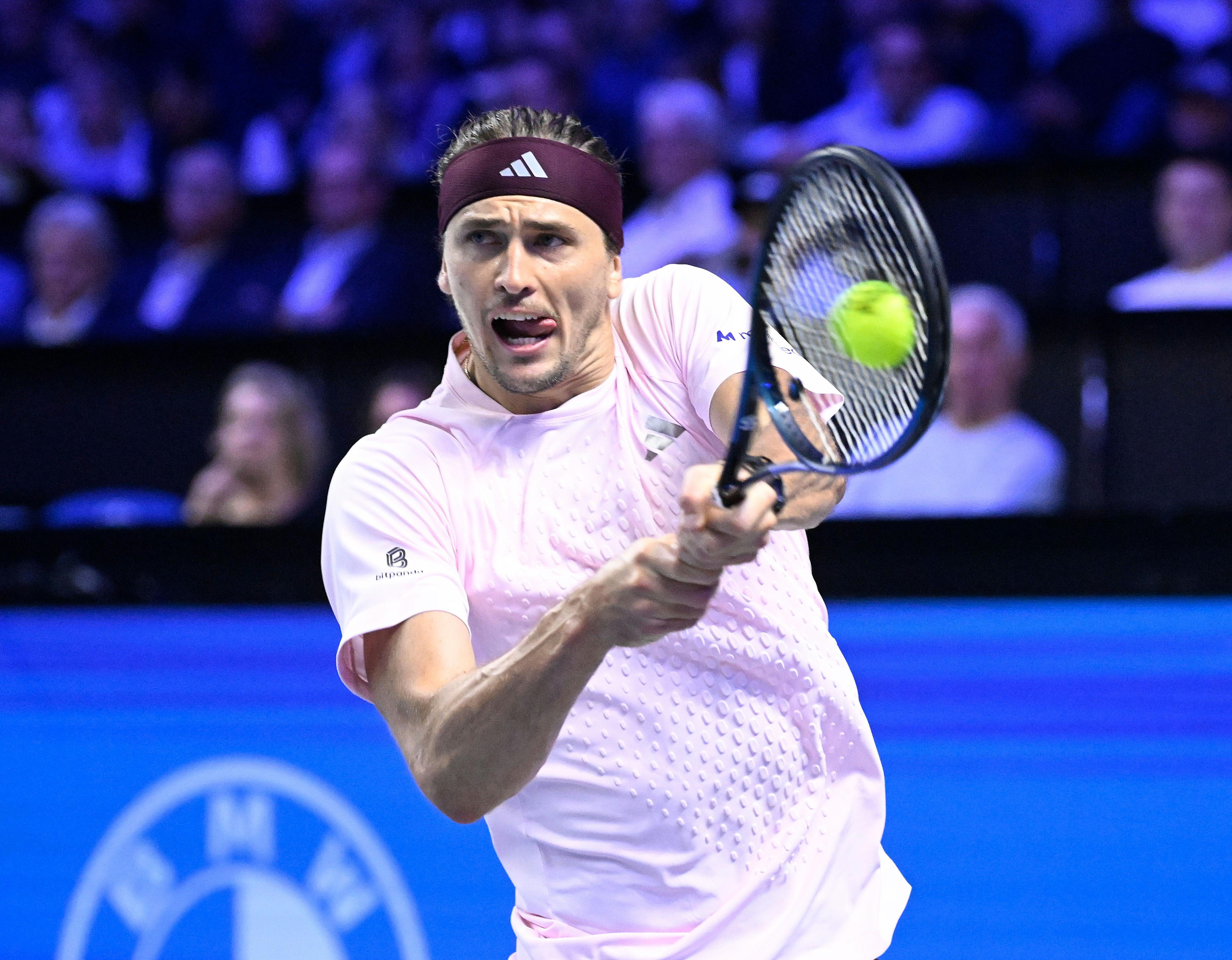 Ein Tennisspieler trifft den Ball mit einem beidhändigen Rückhand-Schlag während eines Matches.