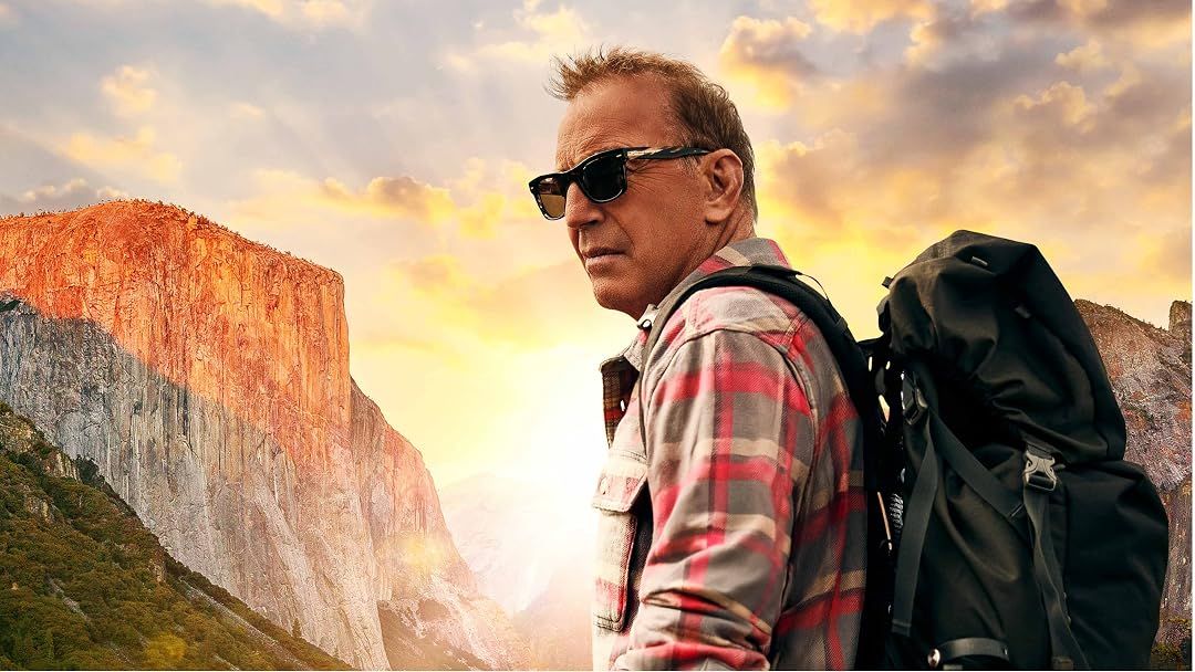 Mann mit Sonnenbrille und Rucksack in den Bergen bei Sonnenuntergang.