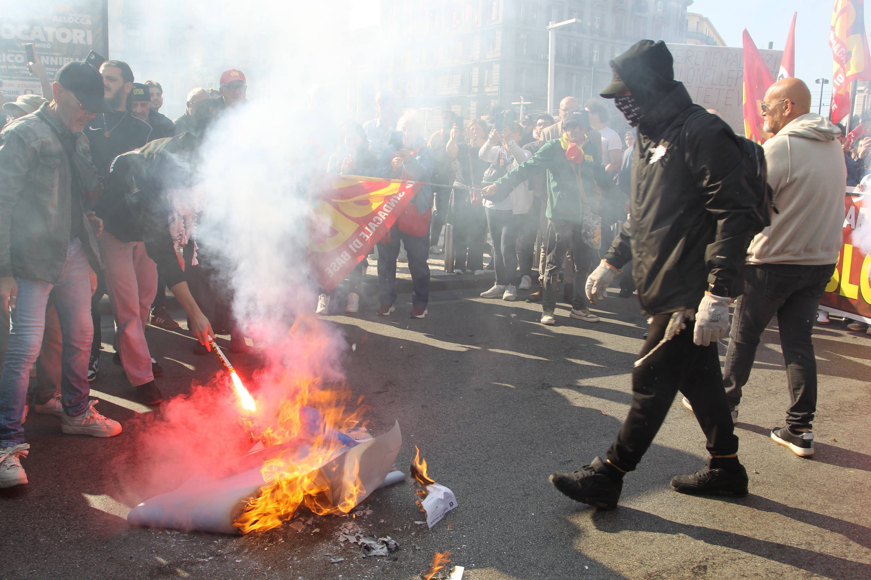 Demonstranten verbrennen Gegenstände auf der Straße bei einem Protest in Neapel, Italien.