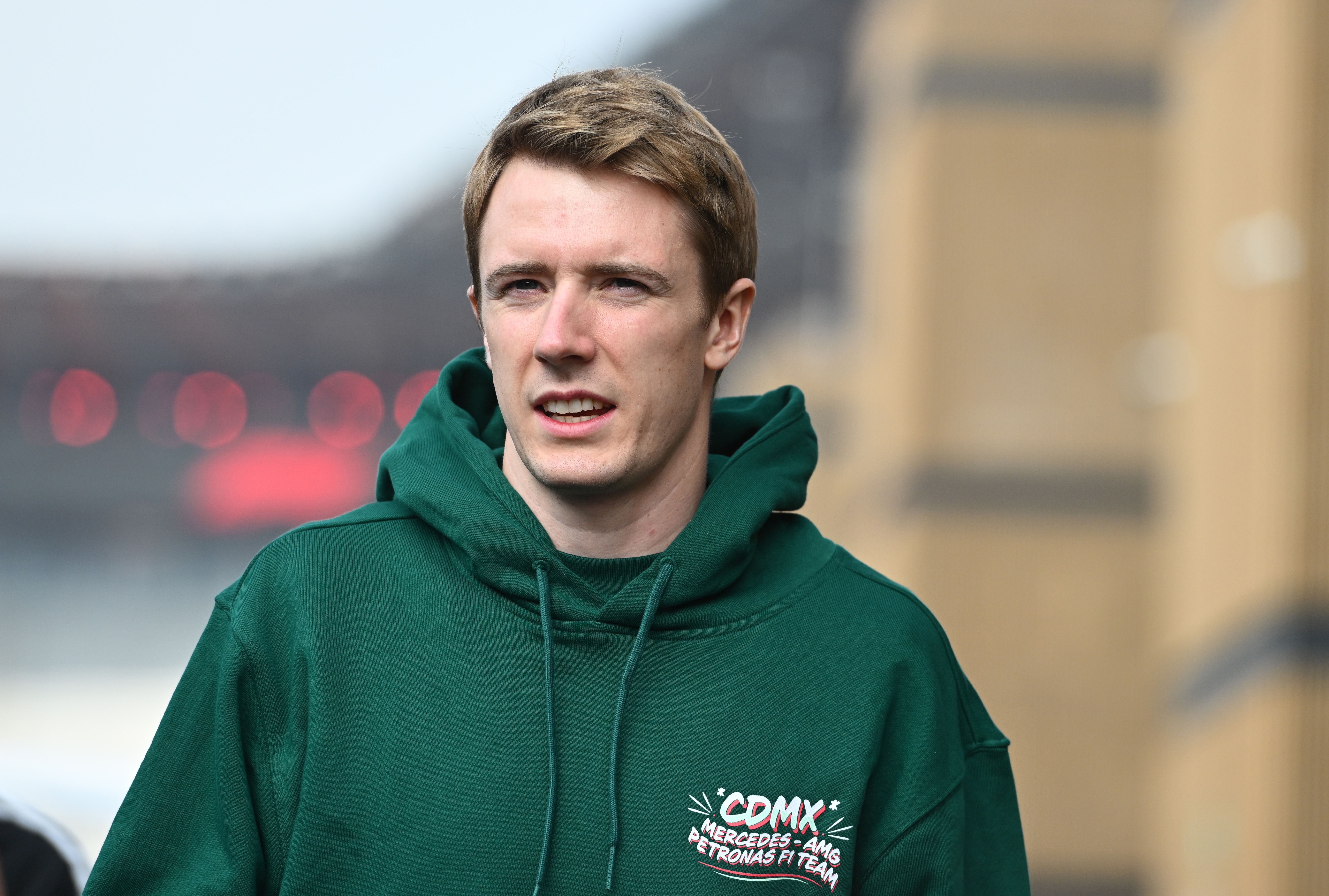 Frederik Vesti blickt im grünen Hoodie des Mercedes-AMG Petronas F1 Teams aufmerksam zur Seite.