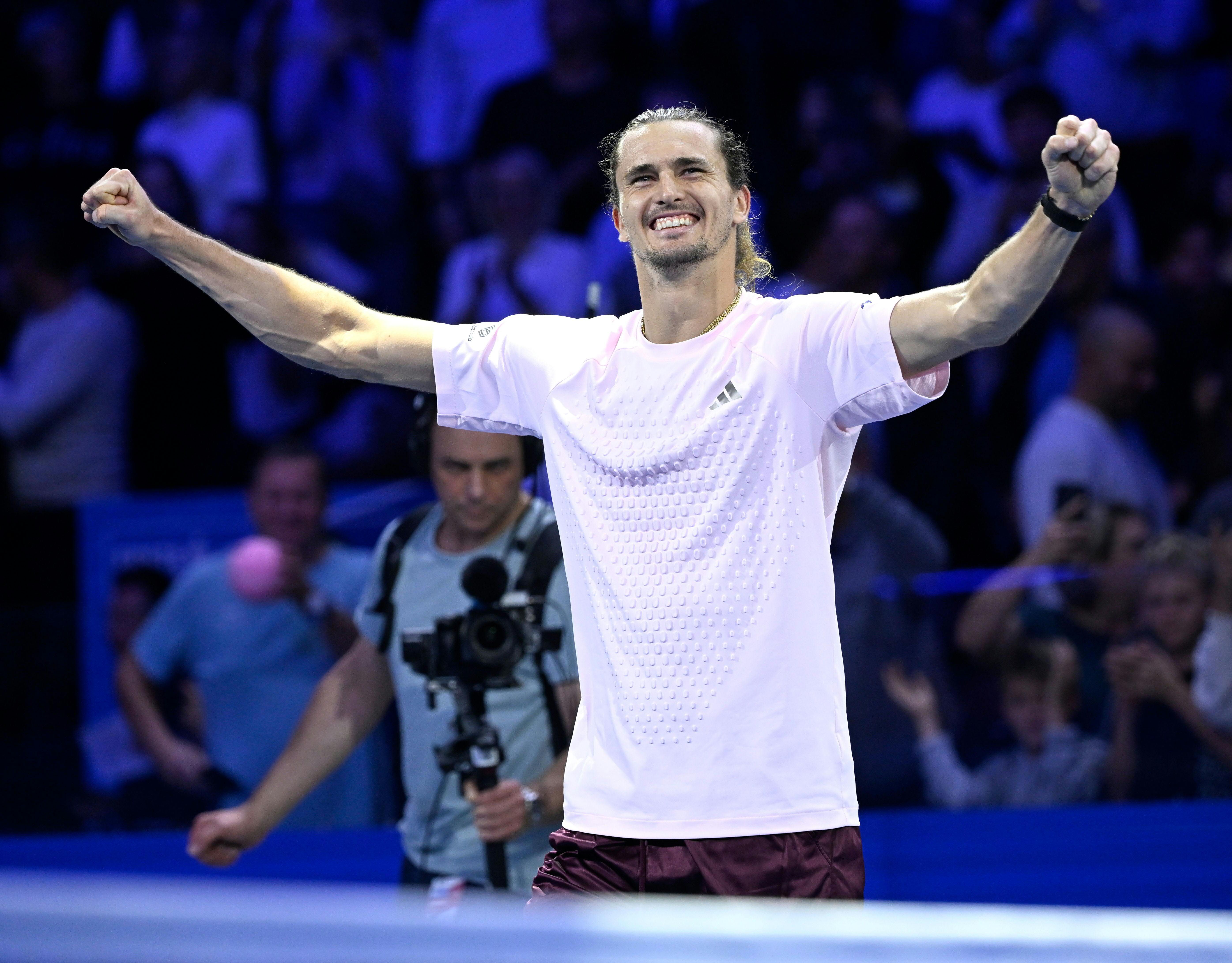 Alexander Zverev jubelt mit erhobenen Armen auf einem Tennisplatz, Zuschauer im Hintergrund.